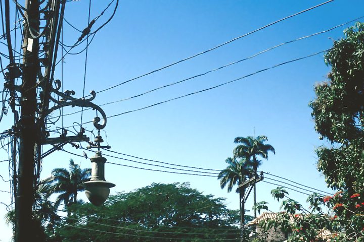 Emaranhado de cabos de energia e telefonia em postes de rua