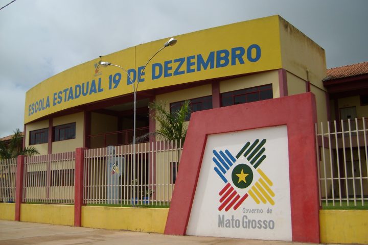 Fachada de escola pública em Mato Grosso com o brasão do Estado