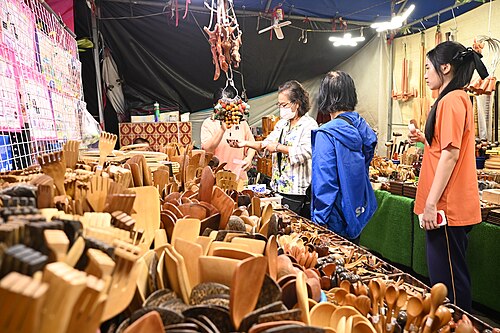 Pessoas visitam banca de artesanato em feira