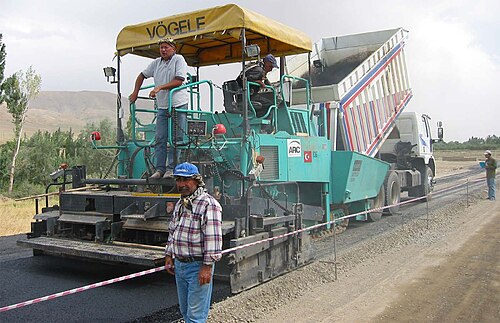 Máquina aplicando asfalto em rodovia