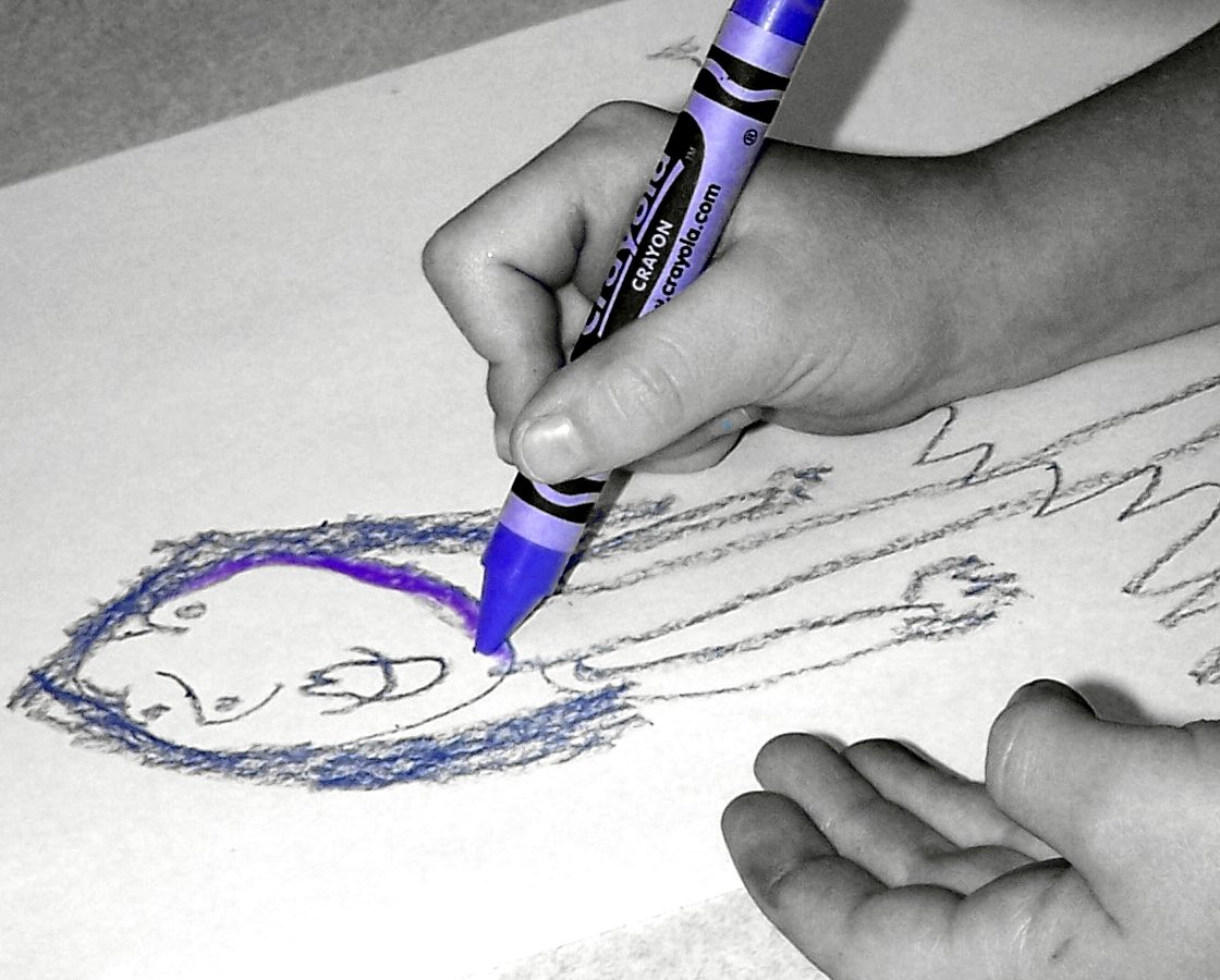 Criança desenha com caneta colorida em atividade recreativa