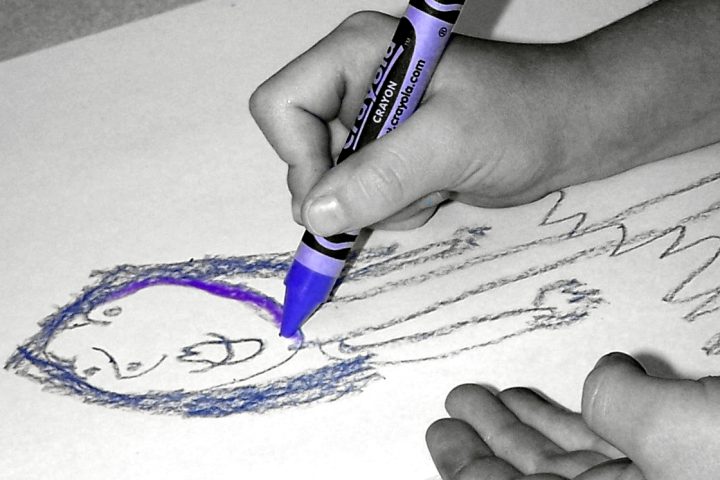 Criança desenha com caneta colorida em atividade recreativa