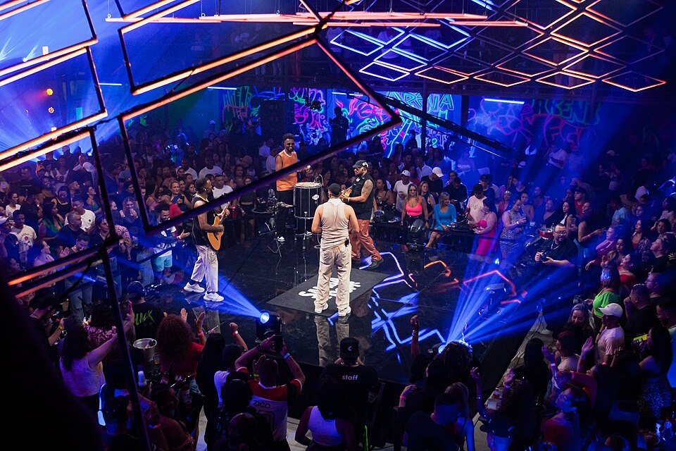 Público em show noturno com palco iluminado