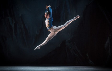 Bailarina executa salto em palco de teatro