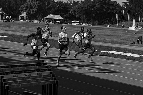 Jovens atletas correndo em pista de atletismo