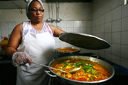 Merendeira serve refeição da alimentação escolar