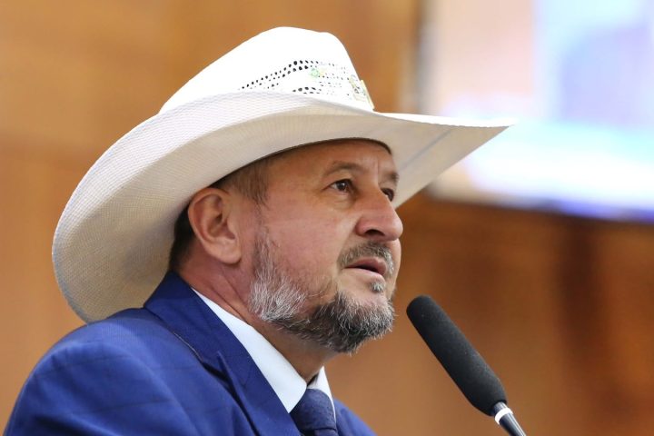 Deputado estadual Gilberto Cattani, de chapéu branco e terno azul, fala ao microfone na tribuna da Assembleia Legislativa de Mato Grosso