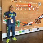 Judoca Pedro Dantas, de camiseta do Brasil, posa diante do painel do École Mont-Olivet Lausanne Grand Slam