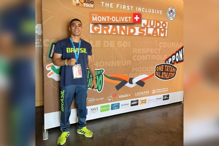 Judoca Pedro Dantas, de camiseta do Brasil, posa diante do painel do École Mont-Olivet Lausanne Grand Slam