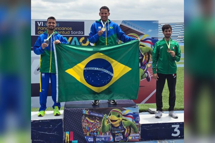 Atleta brasileiro no lugar mais alto do pódio dos 800 metros, com a bandeira do Brasil, em Guayaquil