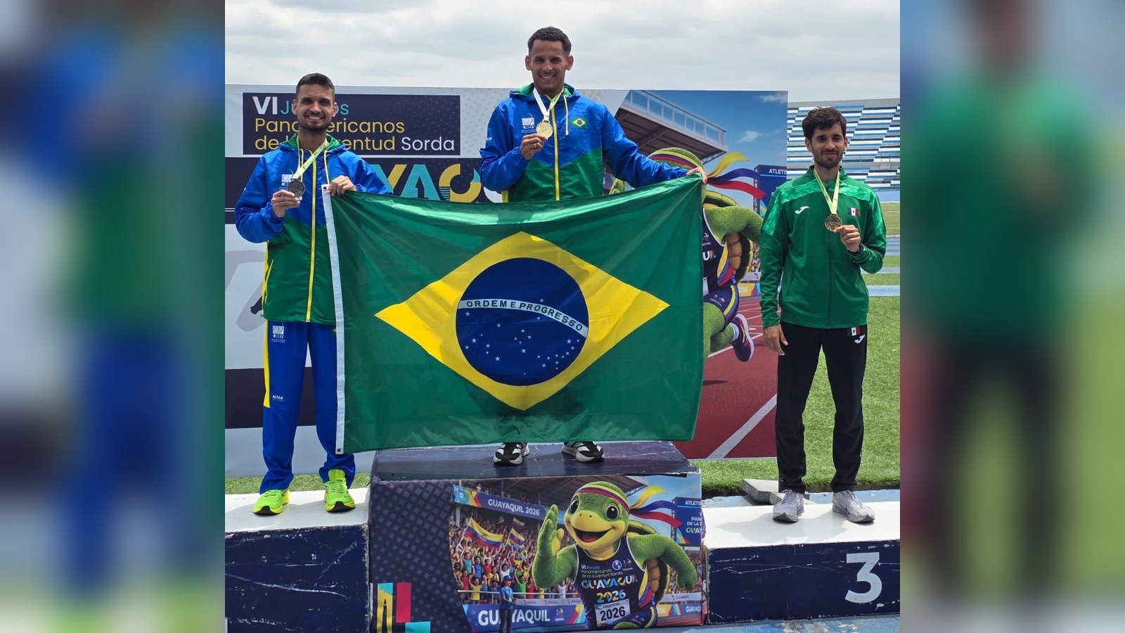 Atleta brasileiro no lugar mais alto do pódio dos 800 metros, com a bandeira do Brasil, em Guayaquil