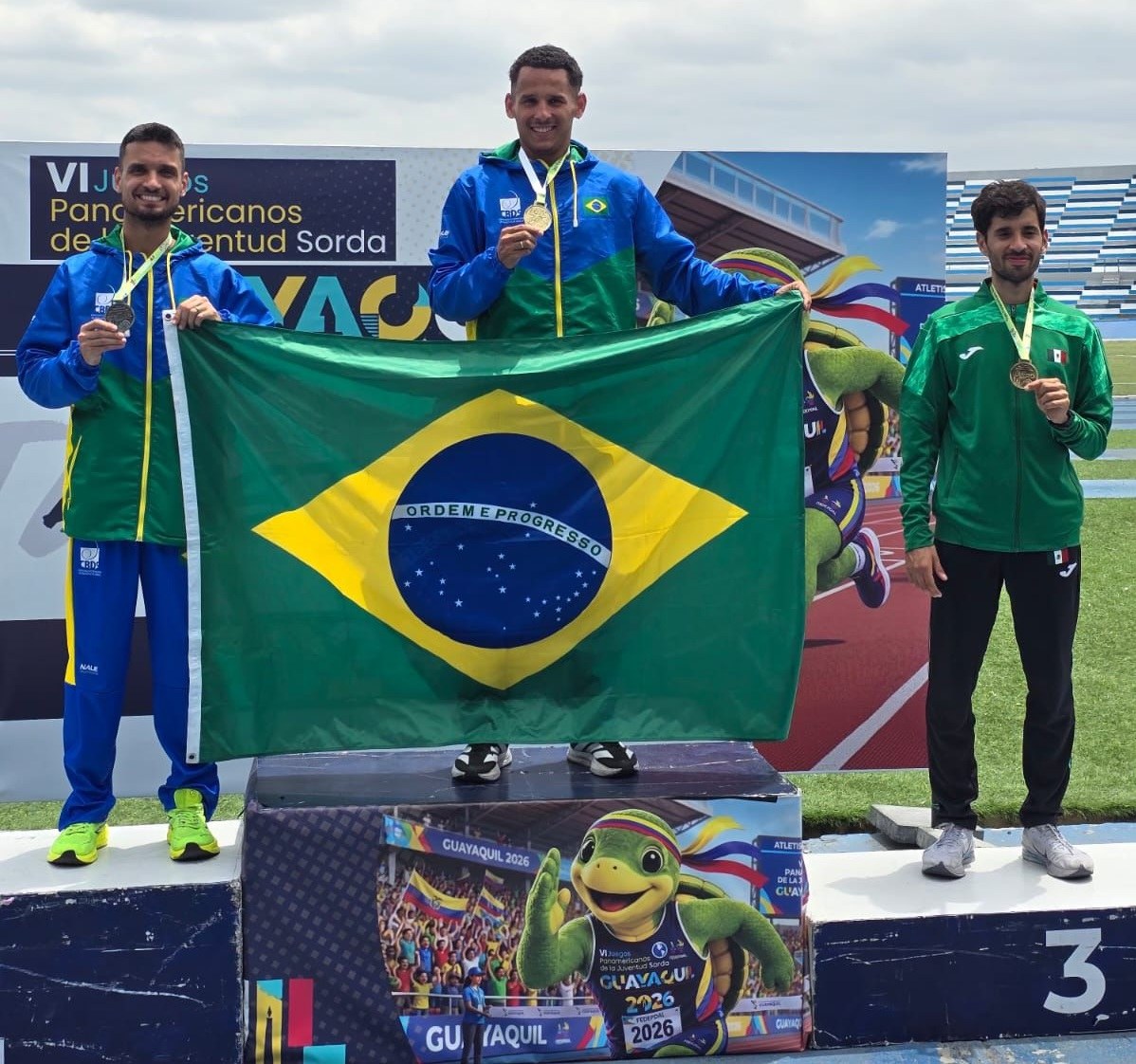 Pódio dos 800 metros com dois atletas brasileiros segurando a bandeira do Brasil
