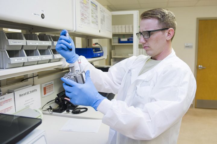 Profissional manipula amostras em laboratório