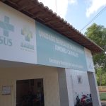 Fachada de uma Unidade Básica de Saúde com placa do SUS e da Secretaria Municipal de Saúde