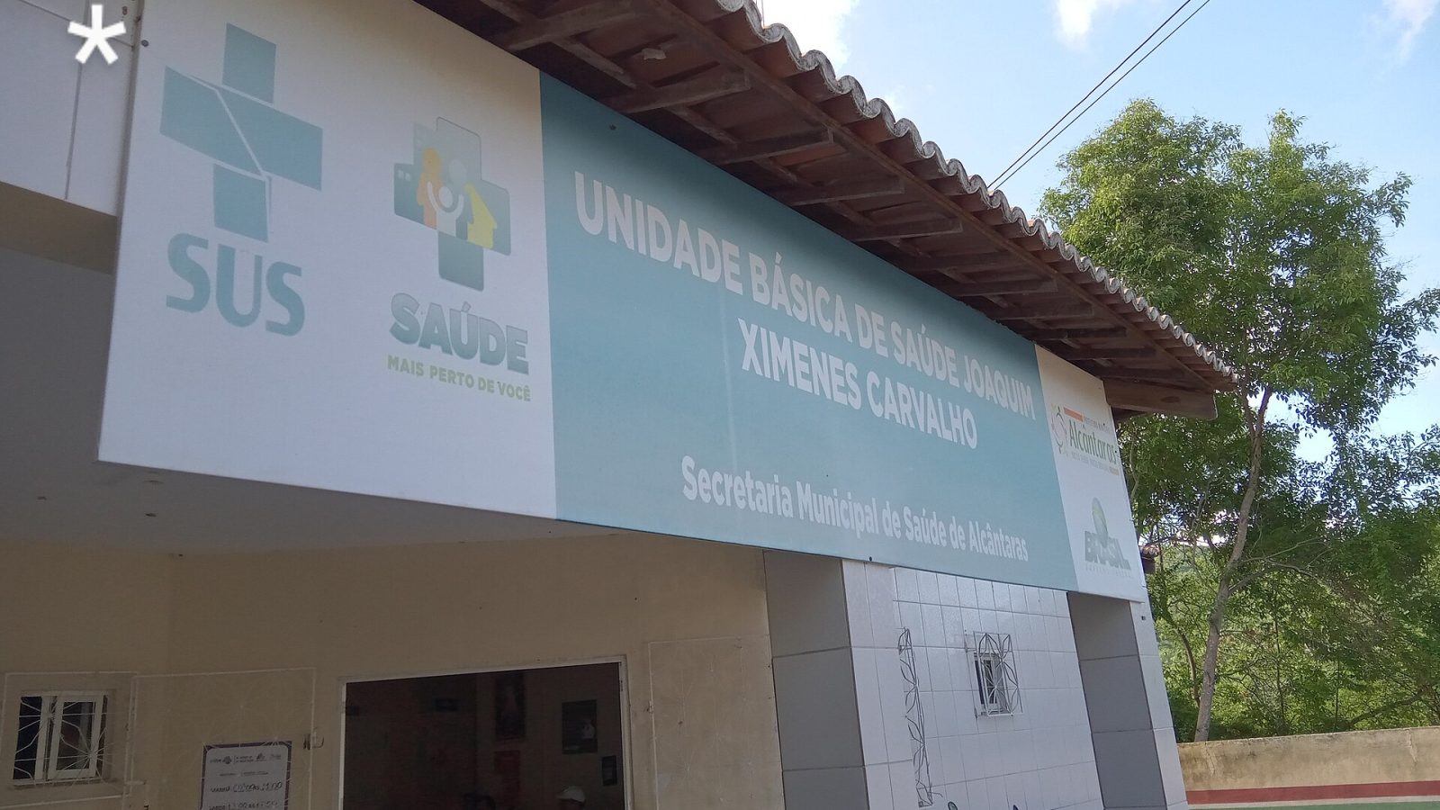 Fachada de uma Unidade Básica de Saúde com placa do SUS e da Secretaria Municipal de Saúde