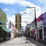 Rua de comércio com lojas e pedestres no Centro Histórico de Cuiabá