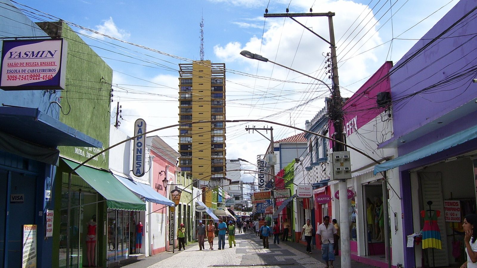 Rua de comércio com lojas e pedestres no Centro Histórico de Cuiabá