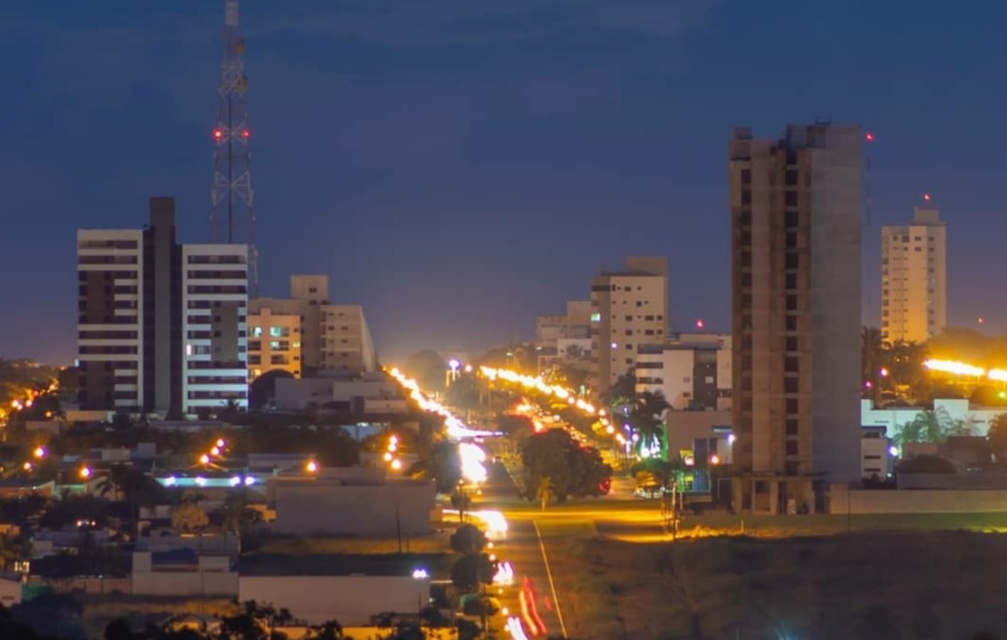 Vista noturna de Sorriso, com prédios e avenida iluminada