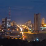 Vista noturna de Sorriso, com prédios e avenida iluminada