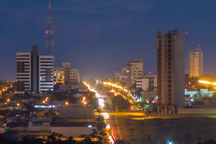 Vista noturna de Sorriso, com prédios e avenida iluminada