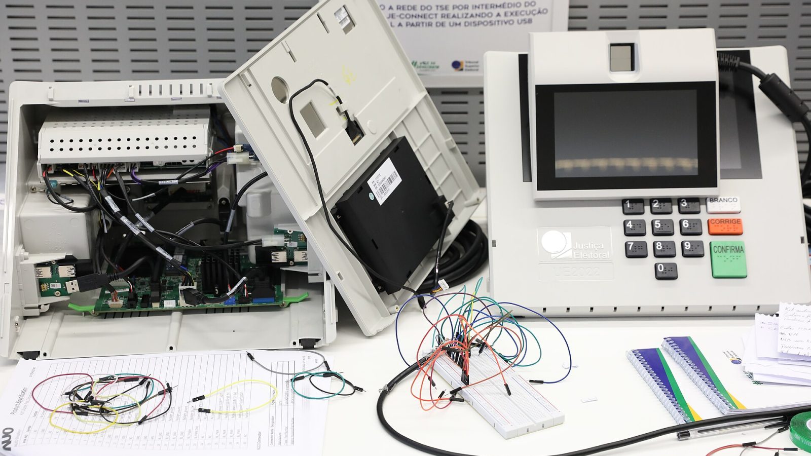 Urna eletrônica brasileira aberta, com placas e componentes internos expostos para inspeção