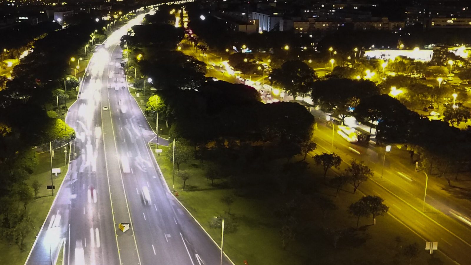 Vista aérea noturna de avenida com iluminação pública de LED em Brasília