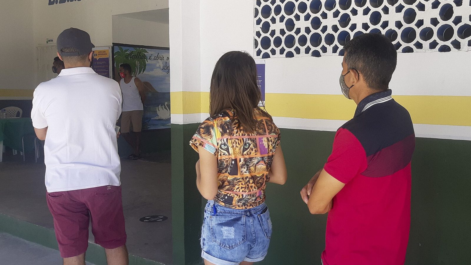 Eleitores em fila na porta de uma seção eleitoral em escola