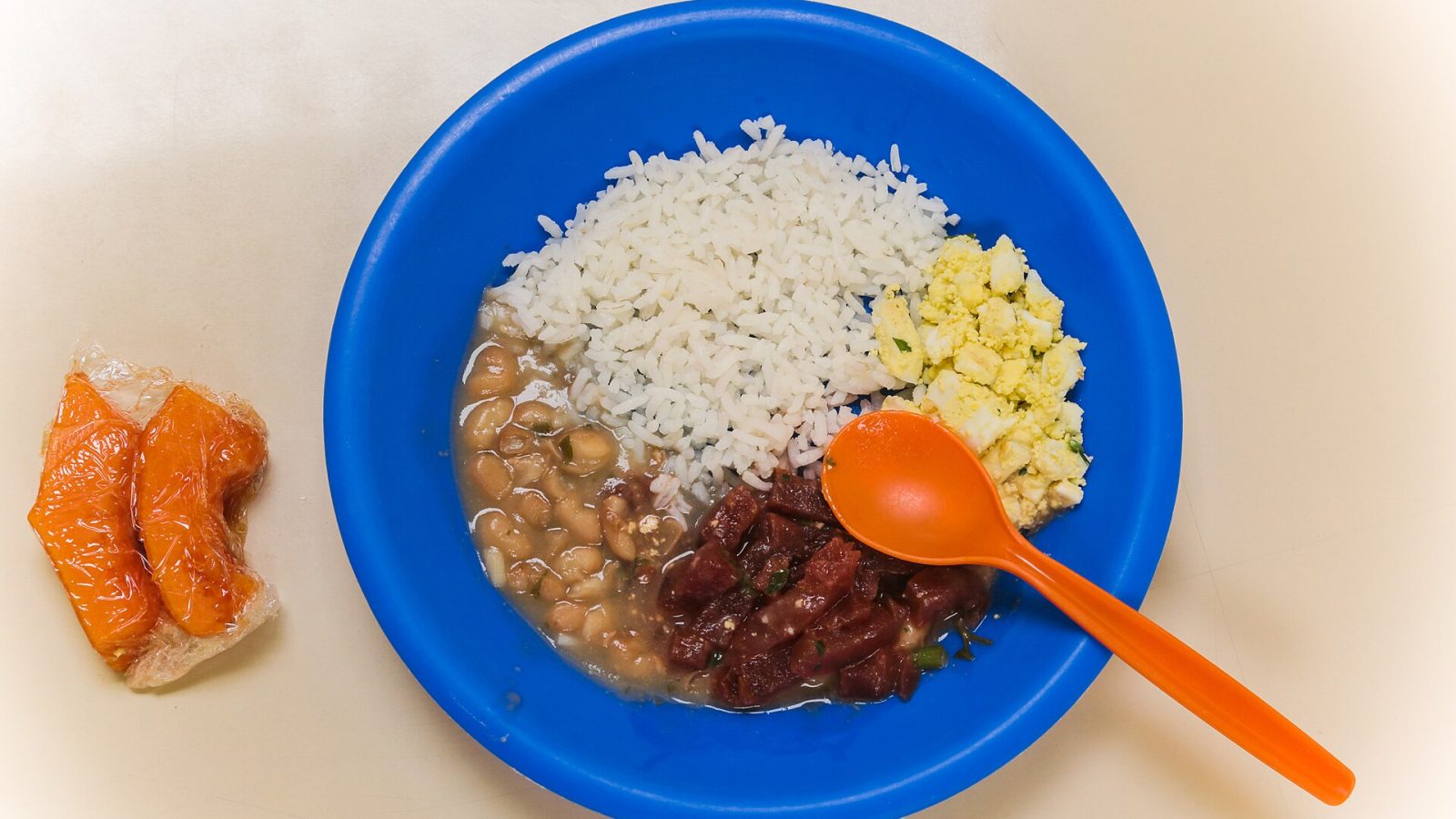 Prato de merenda escolar com arroz, feijão e carne, servido em escola pública