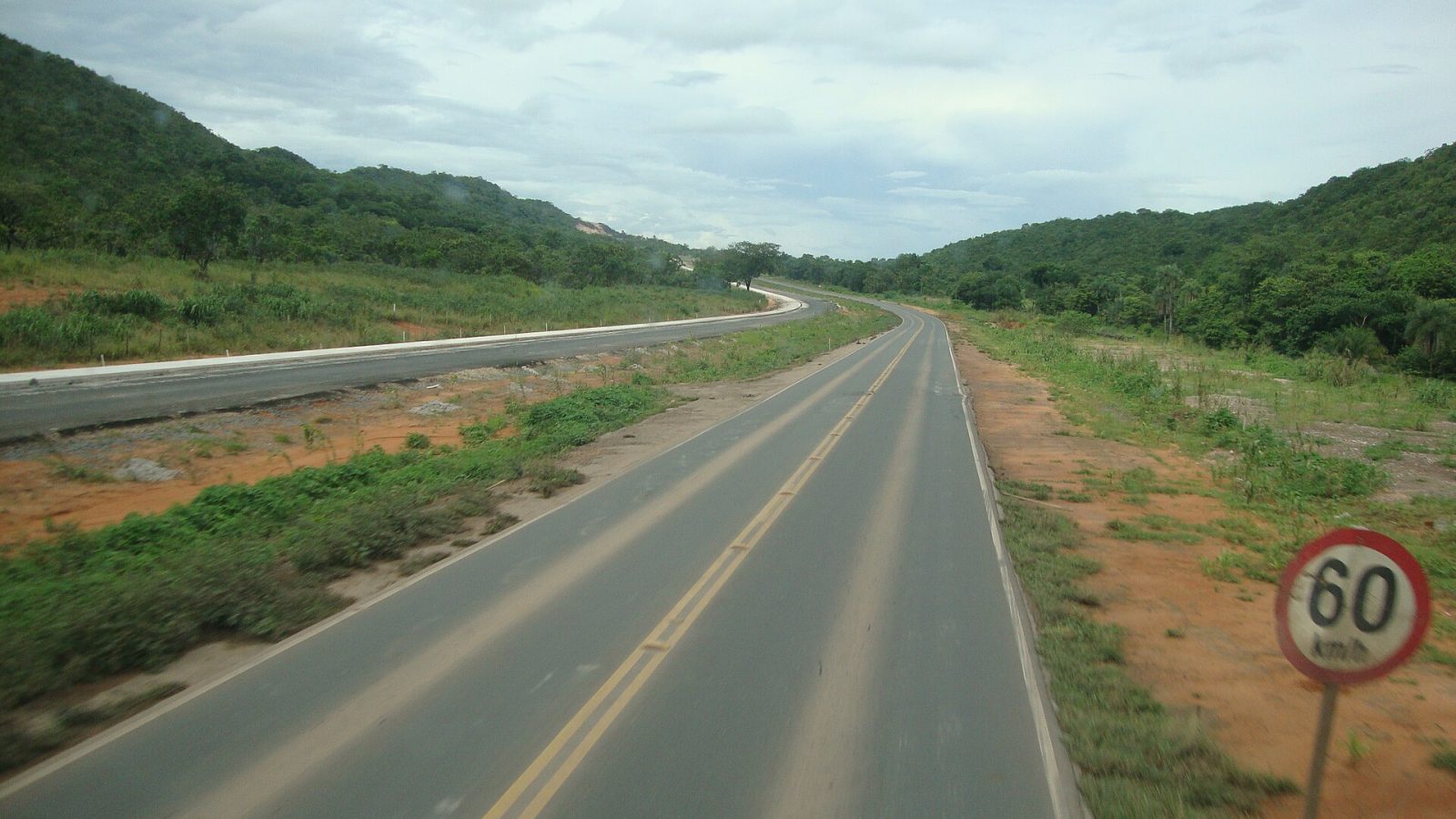 Trecho duplicado da BR-364 entre morros em Mato Grosso, com placa de limite de 60 km/h