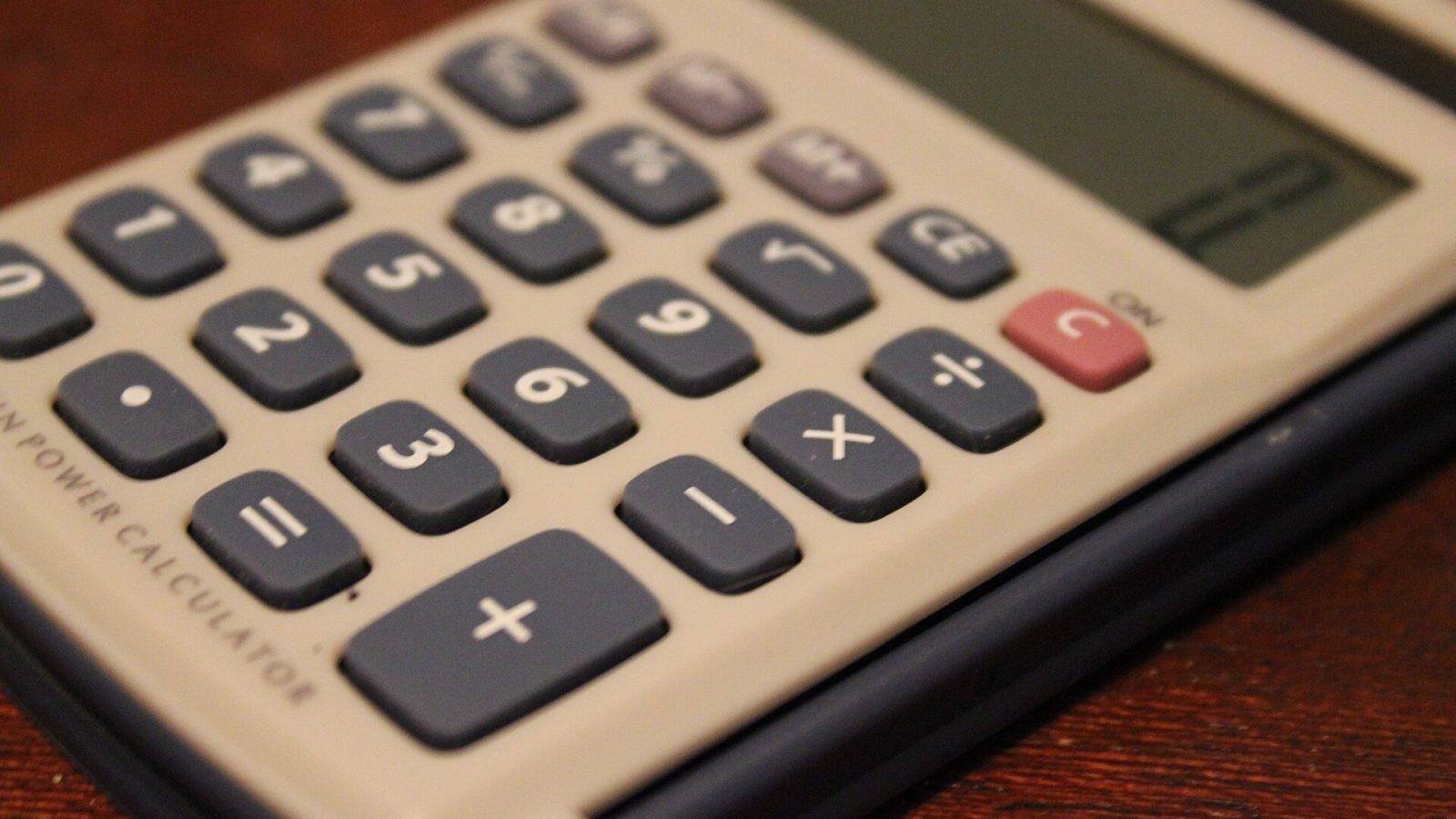 Calculadora de bolso vista de perto sobre uma mesa de madeira