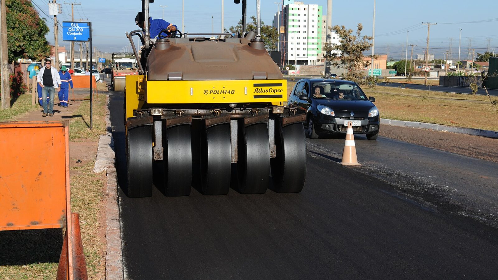 Rolo compactador trabalha em pavimentação asfáltica de via urbana