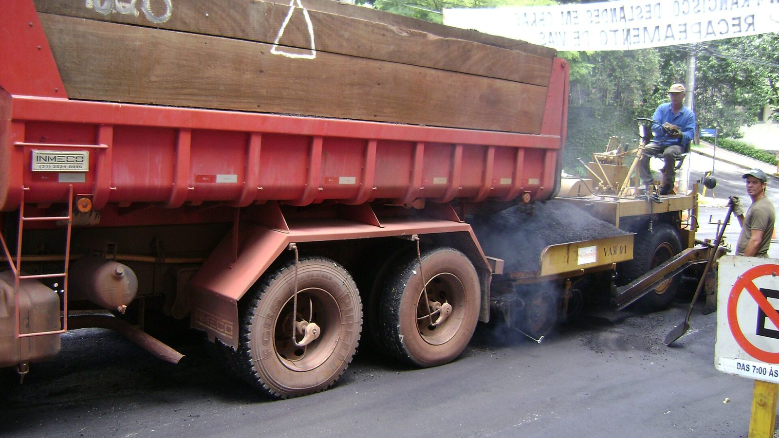 Trator despejando asfalto para recapeamento de avenida