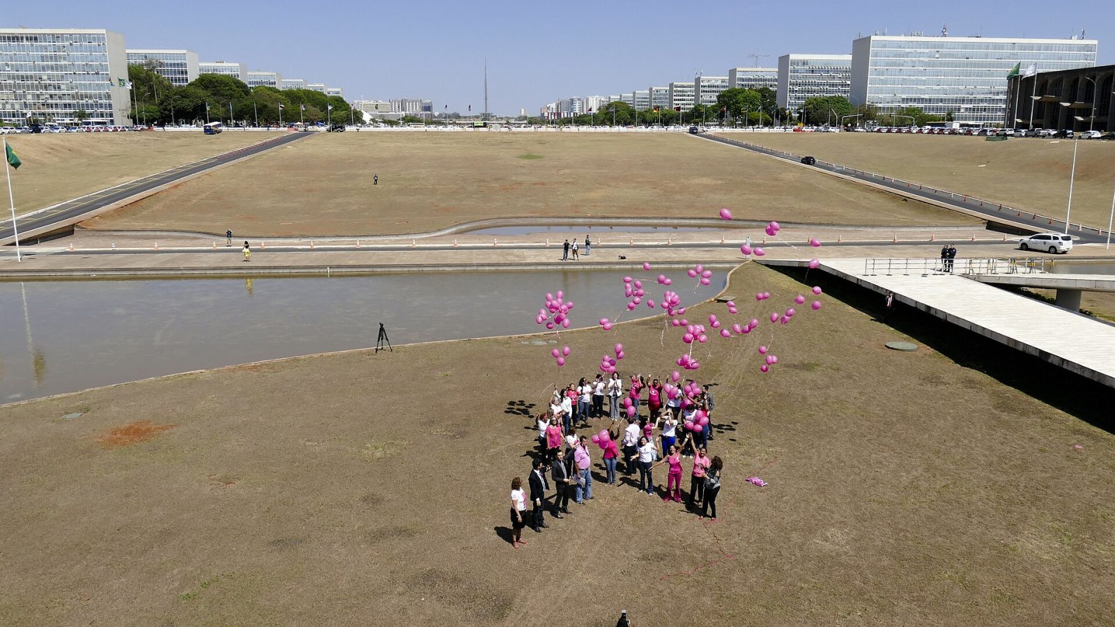 Grupo reunido com balões rosa em ação do Outubro Rosa