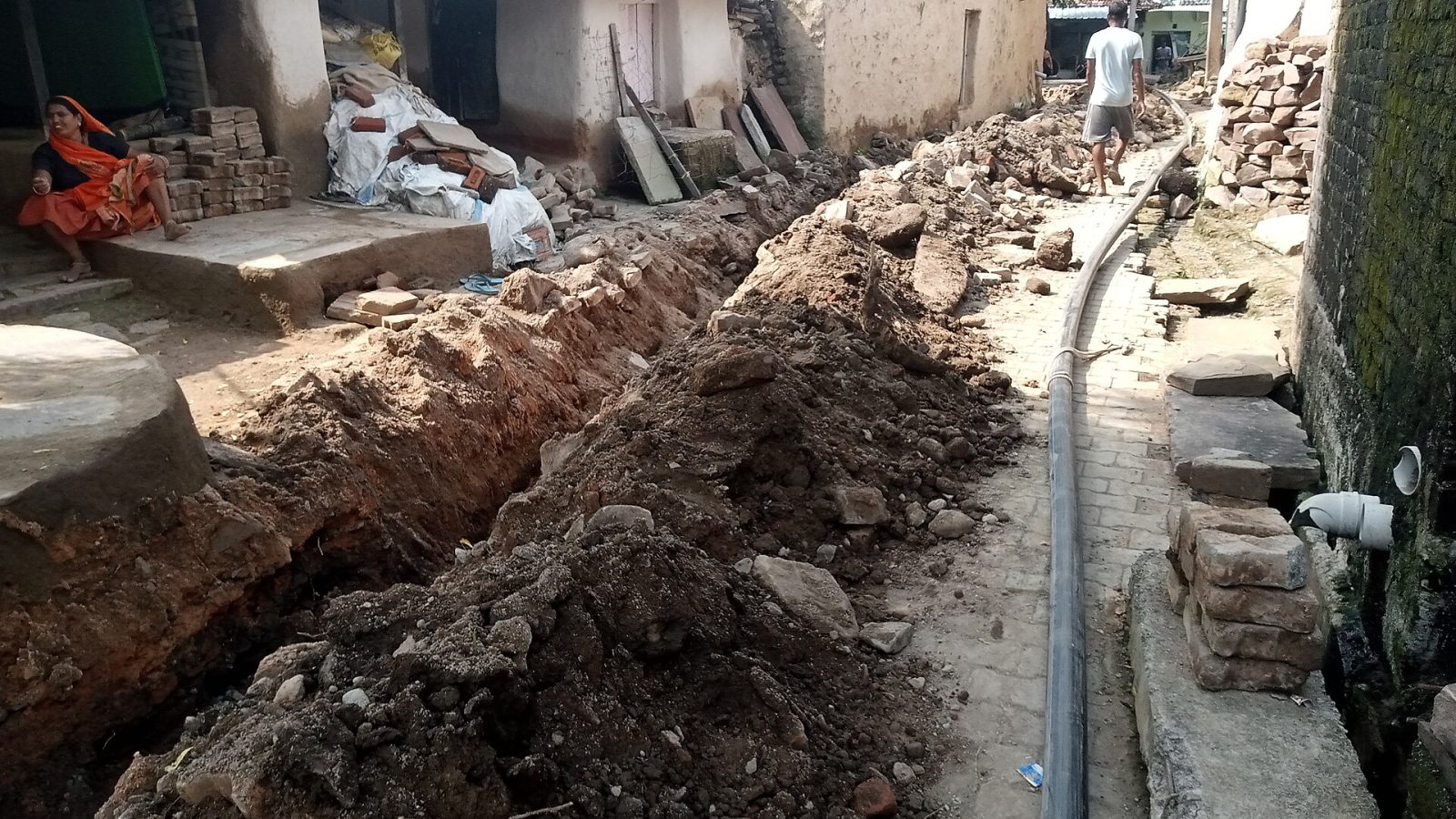 Vala aberta com tubulação de água em obra de rede