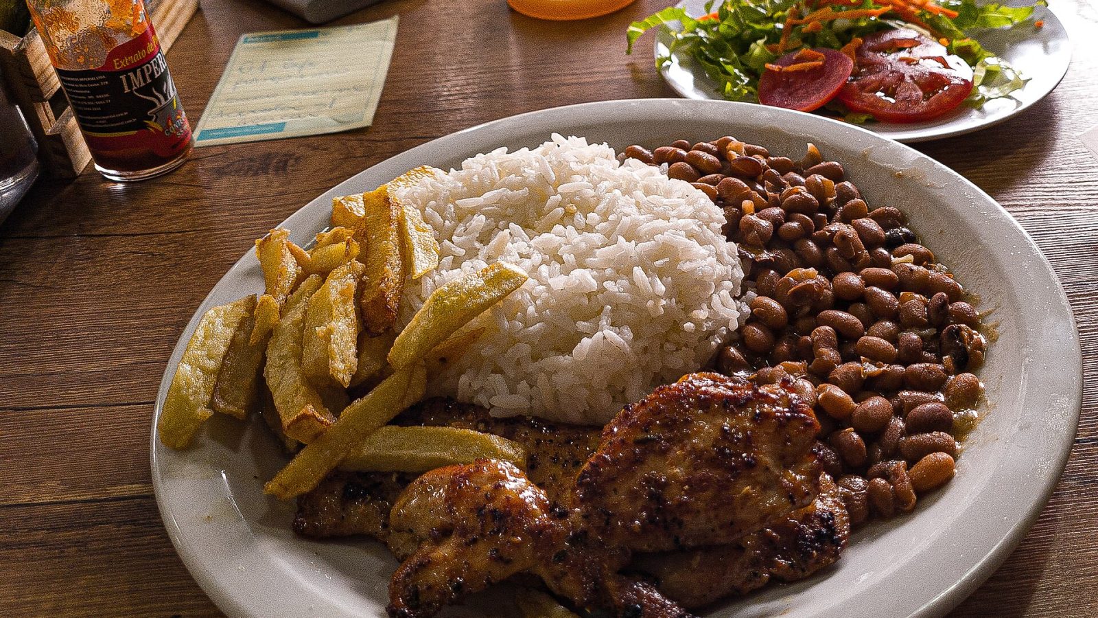 Prato com arroz, feijão, frango, batata frita e salada
