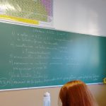 Sala de aula com carteiras e quadro
