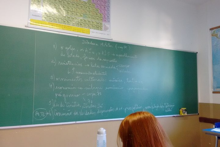 Sala de aula com carteiras e quadro